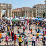 Vue sur le forum des associations avec des stands et des personnes pratiquant du yoga en extérieur à Montpellier.