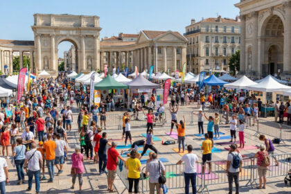 Vue sur le forum des associations avec des stands et des personnes pratiquant du yoga en extérieur à Montpellier.