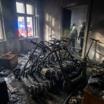 Pompiers inspectant un appartement calciné rempli de dizaines de trottinettes électriques brûlées.