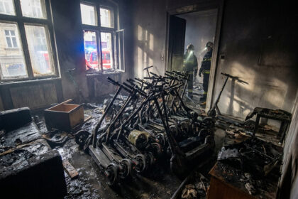 Pompiers inspectant un appartement calciné rempli de dizaines de trottinettes électriques brûlées.